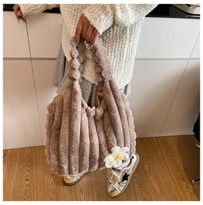 Detail of light coffee plush tote bag with soft faux fur texture and crochet flower charm