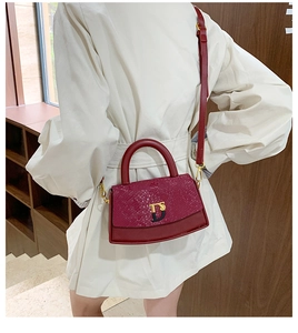Model view of a red snakeskin embossed crossbody box bag with a gold D-buckle closure