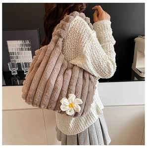 Detail of brown plush tote bag featuring a knit daisy and vertical fuzzy texture