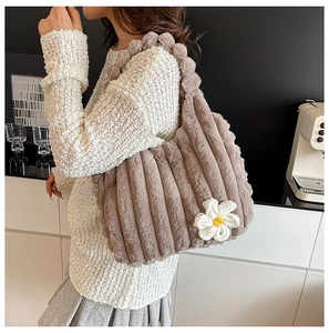 Detail of brown plush tote bag with stripe texture and white daisy floral accent