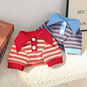 Detail of striped polo pet shirts with knit cotton fabric and white buttons on a cozy rug