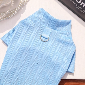 Close-up of sky blue knit pet sweater with metal D-ring and elegant cable texture