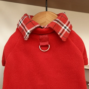 Detail of red fleece pet sweater with plaid collar and metal D-ring for leash attachment