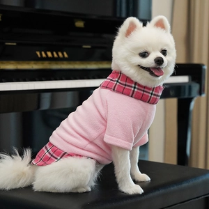 Pink fleece pet vest with British plaid collar and hem on a small white dog