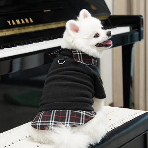 Detail of plaid fleece pet coat with D-ring buckle on a white Pomeranian dog
