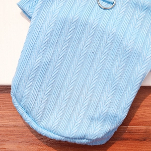Close-up of light blue pet knit sweater featuring thick herringbone texture and metal D-ring