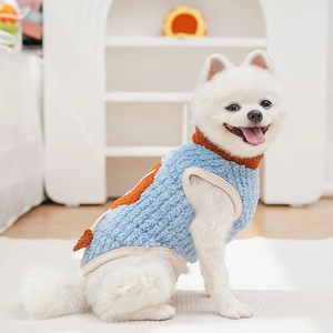 Detail of blue fleece pet vest with orange dinosaur spikes and soft beige piping finish
