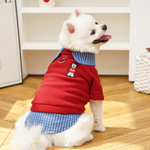 Detail of red polar fleece dog coat with bear patch embroidery and metal D-ring attachment