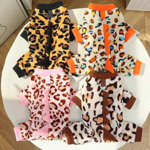 Detail of four dinosaur-style leopard print pet jumpsuits with metal D-rings and fleece