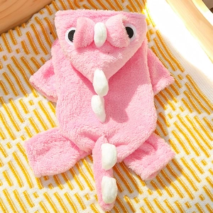 Detailed close-up of pink dinosaur pet onesie in soft plush fabric on a cozy background