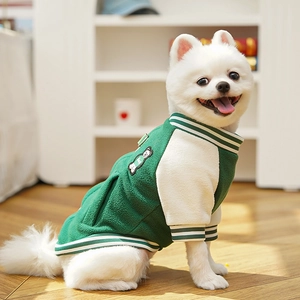 Detail of green fleece pet baseball jacket with bear patch on a small white dog