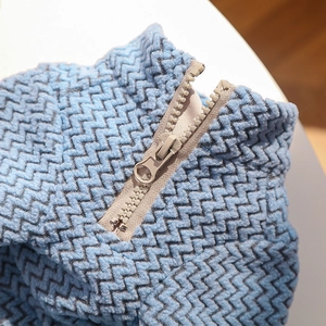 Detail of dog sweater with zigzag knit texture and round ring zipper pull closure