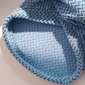 Close-up of blue wavy knit fabric texture and high-quality edge stitching for pet clothes