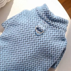 Detailed view of blue wavy knit texture and silver metal D-ring on pet sweater
