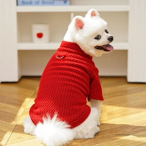 Detail of red knitted pet sweater featuring a 3D wave texture and a metal D-ring for leashes