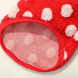 Gros plan d'un vêtement en peluche rouge à pois pour animaux avec doublure antidérapante