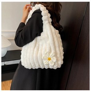 Detail of white plush tote bag with ribbed texture and handmade daisy flower charm
