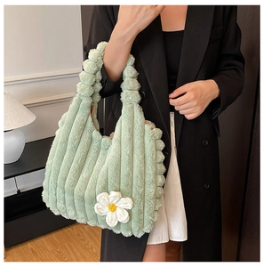 Detail of light green plush tote bag with white daisy flower and vertical ribbed texture