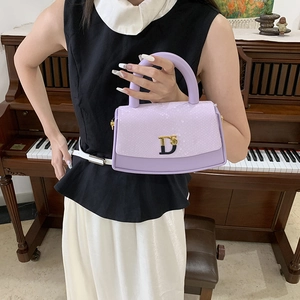 Elegant purple snakeskin texture handbag with metal D-buckle on a piano background