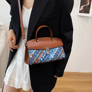 Brown leather handbag with colorful woven texture and top handle shown on model