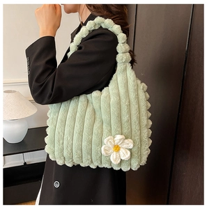 Detail of light green plush tote bag with vertical stripes and a white daisy floral accent