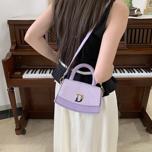 Detail of lavender snakeskin embossed leather handbag with gold D5 metal logo and strap