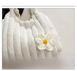 Detail shot of white plush tote bag with vertical stripes and woven flower decor