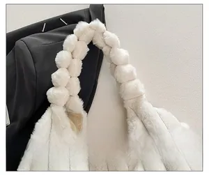 Detail of white plush tote bag showing the comfortable wide woven strap and soft fur texture