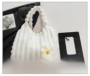 Detail of white plush tote bag featuring striped faux fur texture and crochet flower charm