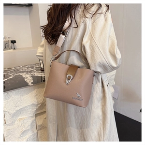 Detailed close-up of brown bucket bag with lychee grain PU leather and logo hardware