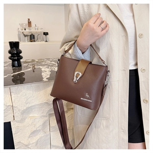 Detail of dark brown bucket bag with lychee texture leather and silver hardware details