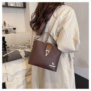 Detailed macro view of dark brown lychee grain leather bucket bag with silver hardware