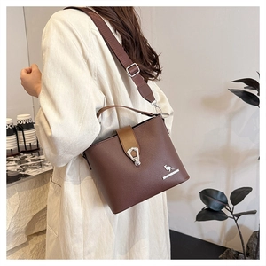 Detail of vintage brown bucket bag showing wide adjustable strap and logo branding