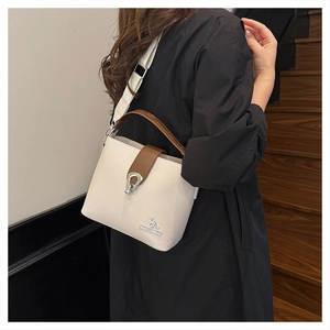 Detail of white litchi pattern leather bucket bag with brown handles and gold kangaroo logo