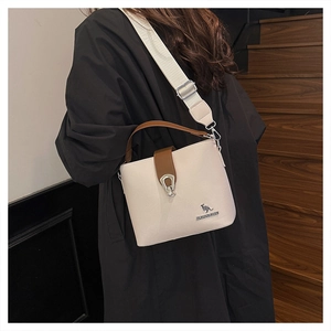 Detailed close-up of cream bucket bag with lychee grain texture and gold kangaroo logo
