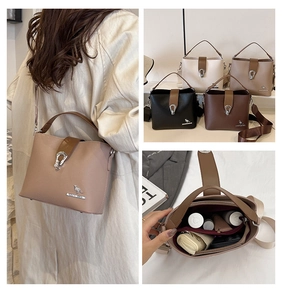 Detailed interior of a leather bucket bag showing compartments for phone and cosmetics