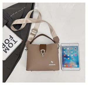 Top view of khaki bucket bag showing size comparison with a tablet and magazine
