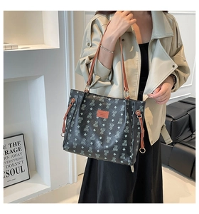Detail of fashion tote bag featuring bear print pattern and stylish brown shoulder straps