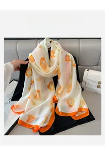 Detail of silk-like beach scarf with orange tulip patterns draped on a black suit blazer