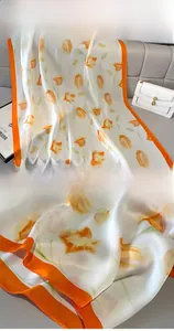 Detail of silk scarf showing orange tulip print and fine rolled edge stitching