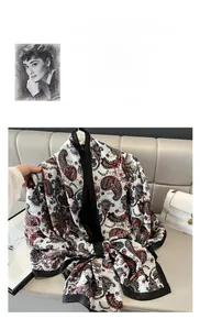 Close-up of vintage paisley print silk scarf with black satin borders on beige sofa