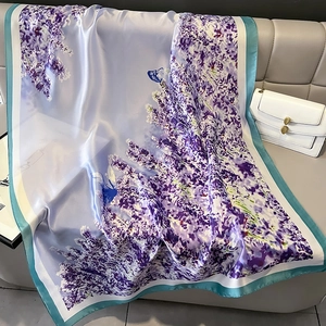 Lavender silk-feel shawl with floral butterfly print on grey leather sofa backdrop