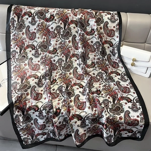 Ethnic paisley print faux silk scarf with elegant black border on leather chair