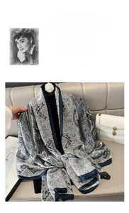 Dettaglio di elegante sciarpa in seta con motivi paisley blu e trama setosa