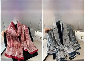 Dettaglio di sciarpe in seta con stampa paisley in rosso e blu su un divano in pelle