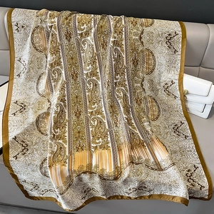 Sciarpa di seta con stampa paisley barocca e motivo geometrico su divano in pelle