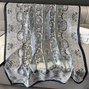 Dettaglio di morbido foulard in raso con stampa paisley e bordi geometrici