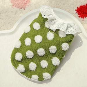 Macro detail of green polka dot pet vest with lace trim and metal D-ring attachment