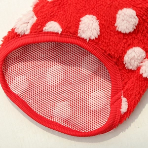 Detailed close-up of thick red coral fleece pet clothes with soft polka dots and ribbed trim