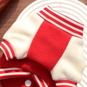 Detail of red fleece dog baseball jacket with striped ribbed cuffs and resin buttons
